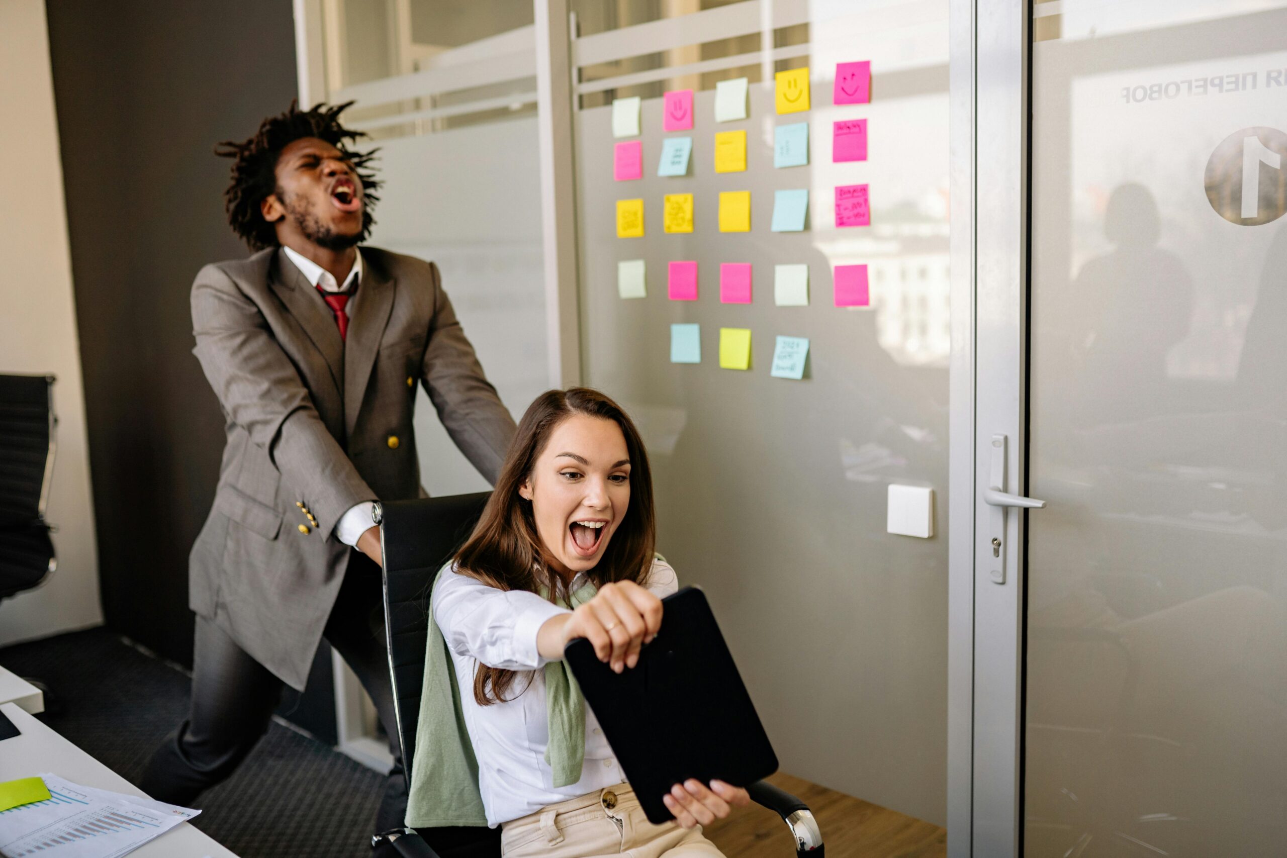 Colleagues enjoying a playful moment in the office, boosting team spirit.